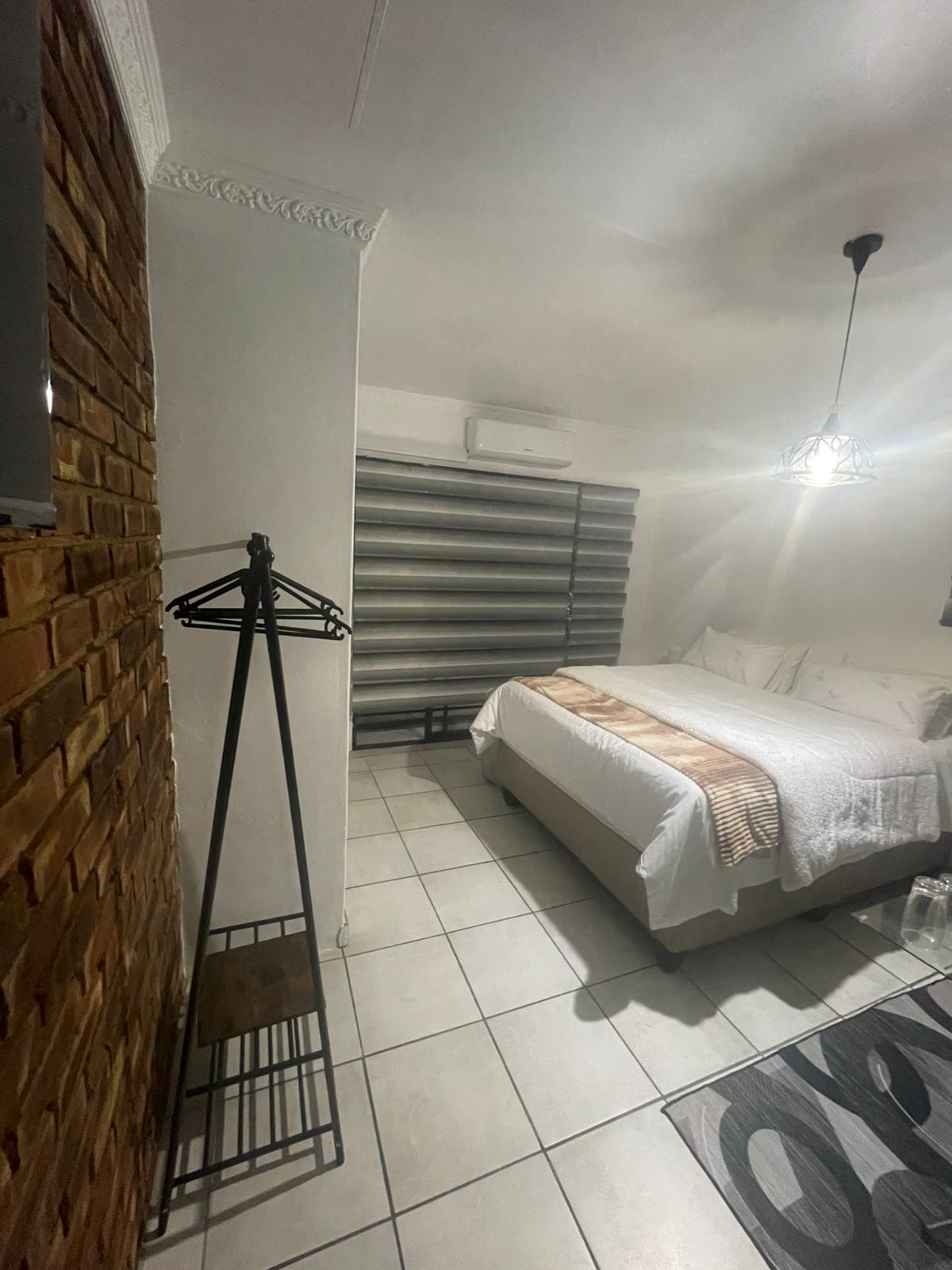 Bedroom with exposed brick and pendant lighting